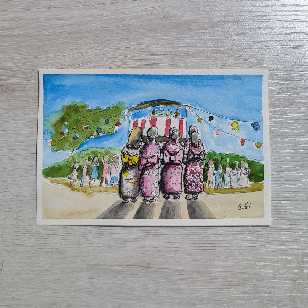 Colorful illustration of women in traditional attire on a street with a banner above, on a wooden surface.