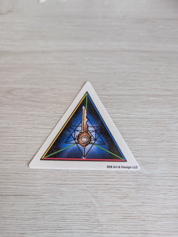 Triangular sticker with geometric design on a textured surface. the key in life is gratitude
