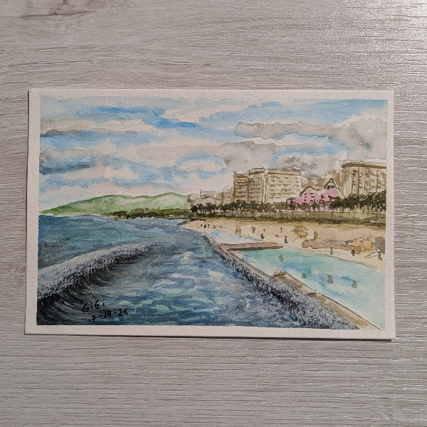 Watercolor painting of a coastal scene with buildings and a beach on a textured gray background made by Gigi the art lady